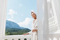 Portrait of gorgeous woman posing against the backdrop of mountains on the balcony architecture Relaxation concept