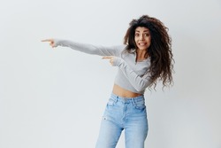 CRAZY OFFER. Amazed Shocked curly beautiful pretty Latin female with afro point fingers aside, show empty place, stay isolated over white background. Promo Huge Sale concept. Copy space, free place