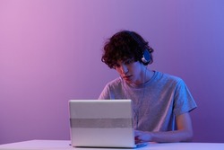 guy cyberspace playing with headphones in front of a laptop isolated background