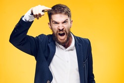 Businessman with a beard on a yellow background, emotions, portrait, boss, anger, scream, aggression.