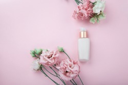 Face cream with fresh pink and white flowers, flatlay on pink background with plenty of copy space. Skin care and ati-ageing cosmetic concept