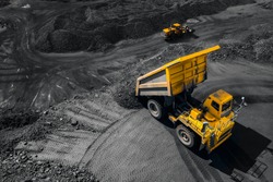 Open pit mine industry, big yellow mining truck for coal, top view aerial drone.