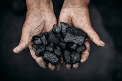 Miner holds coal palm. Concept mining. Top view