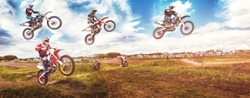 Banner rider mountain dirtbike enduro participates in motocross, jumps on springboard against background dirt. Concept extreme action sport racing.