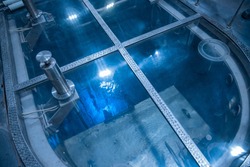 Blue glow water of nuclear reactor core powered, caused by Cherenkov radiation, fuel plates industrial uran.