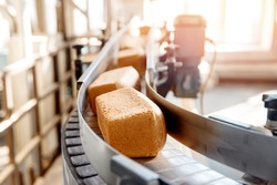 Baked square breads on conveyor food automatic production line bakery from hot oven.