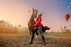 Jockey woman rider brown horse background hot air balloons Cappadocia Goreme National Park Turkey.
