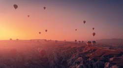 Amazing Panoramic view sunrise rocky landscape in Cappadocia with colorful hot air balloon deep canyons, valleys. Concept banner travel Turkey.