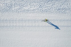 Aerial sportsman with cross country skiing sport background winter forest, top view