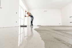 Leveling with mixture of cement for floors. Worker use screed concrete epoxy for level.