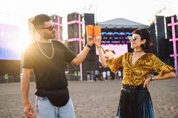 Lovely couple having fun at festival.  Young friends with beer at beach party. Summer holiday, vacation concept. Friendship and celebration concept