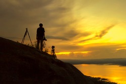 Silhouette photographer on mountain wait shooting sunset,Beauty sunset,Taking photo photographer with sunset
