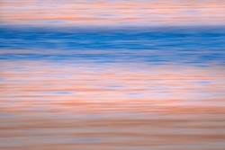 A motion blur applied to an ocean shore at sunset. The combination of beautiful blue and pale apricot  horizontal lines invoke a sense of calm and serenity, and are a perfect backdrop for type. 