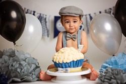 Adorable happy baby boy in a bright room. The baby smiling looking at camera. Retro style