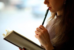 Female reading a book, closeup, background