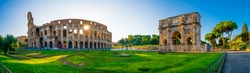 Panorama of Colosseum and Constantine arch at sunrise in Rome, Italy 