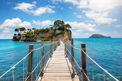 The wooden footbridge leading to the small island of Agios Sostis on Zakynthos, Greece, during a sunny summer day