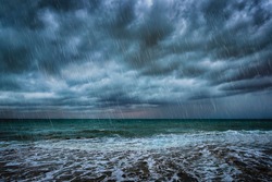 A background with dark clouds, heavy rain and waves on a stormy sea