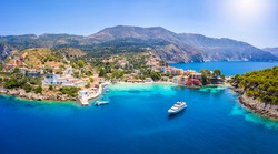 Aerial view to the beautiful fishing village of Assos on the island of Kefalonia, Greece, surrounded by turquoise sea and green hills with Pine Trees