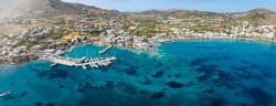 Panoramic aerial view of the beach and marina of Finikas, Syros island, Greece, with turquoise sea