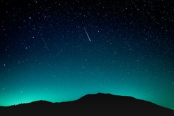 Shooting star above the mountain in dramatic night view