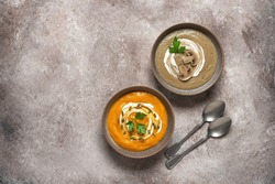 Mushroom and pumpkin cream soup on a brown grunge background. Warm winter soup. Top view, flat lay. Healthy vegetarian food concept. Textured object.