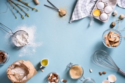 Baking or cooking background frame. Ingredients, kitchen items for baking cakes. Kitchen utensils, flour, eggs, almond, cinnamon, oil. Text space, top view.