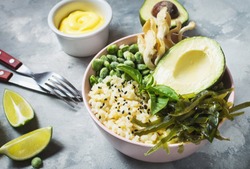 Buddha bowl recipe with quinoa, avocado, lentils, mushrooms, sea kale on concrete background