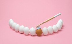 Concept for oral hygiene with a wooden toothbrush, toothpaste, and several eggs simulating the human teeth. Brushing teeth with a wooden toothbrush.
