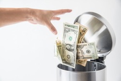 throwing away dollar in trashcan