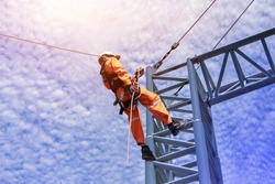 Construction workers wearing safety harness belt during training at high place, Construction workers tying  on road construction structure with on blue sky background