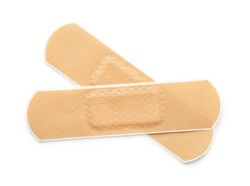 Top view of two beige adhesive bandages isolated on white