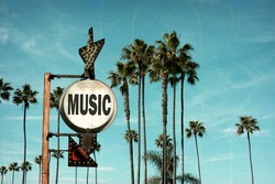 aged and worn vintage photo of music sign and palm trees
