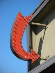red arrow sign with bulbs on building