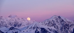 full moon rising over a winter mountain landscape near Klosters in the Swiss Alps