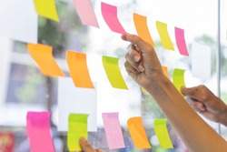 business people post it notes in glass wall at meeting room