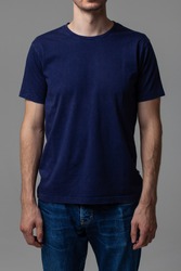 Young male in blank navy t-shirt, front view. Design men t shirt template and mock-up for branding or print. 