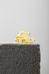 Yellow oil capsules with vitamin D on grey background. Omega 3 tablet. Healthy diet concept