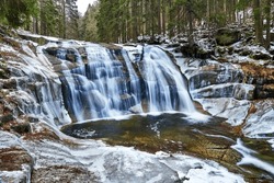 Winter waterfall with ice on the river Mumlava in the Krkonose Mountains