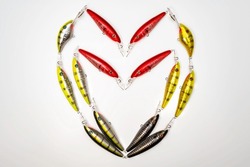 Fishing lures arranged in a heart shape on a white background.