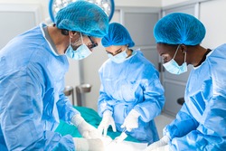 Group of surgeons doing surgery in hospital operating theater. Medical team doing critical operation. Group of surgeons in operating room with surgery equipment. Modern medical background