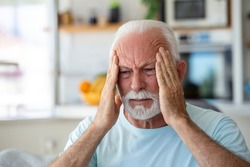 Headache. Senior Man Suffering From Migraine Pain Massaging Temples Sitting At Home. Healthcare, Health Problems In Older Age Concept