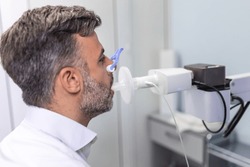 Man testing breathing function by spirometry. Diagnosis of respiratory function in pulmonary disease