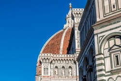 Iconic Renaissance cathedral dome of Florence Cathedral, the Cattedrale di Santa Maria del Fiore or formally the Cathedral of Saint Mary of the Flower, with the blue sky, Florence, Italy