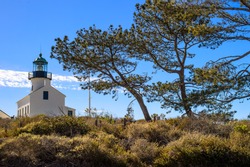 Old Point Loma Lighthouse with blue sky and trees in San Diego, California
