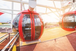 Ferris wheel in amusement park against sky background. Entertainment and fair concept. Close-up view of cabins and gondolas