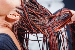 Close-up of afro pigtails braids in Zizi and Kanekalon technique with multi-colored threads and dreadlocks