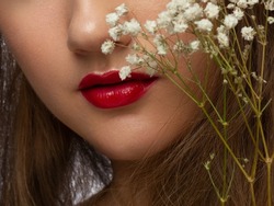 Close-up of woman's lips with fashion bright pink make-up. Beautiful female mouth, full lips with perfect makeup. Part of female face. Choice lipstick. Pink wavy hair of a doll
