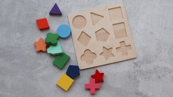 Wood Puzzle with Geometric Shapes. Wooden kids geometric puzzle with the object removed and surrounding puzzle. Montessori wooden toys for children. Sorter for different shapes.