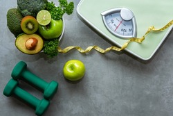 Diet and Healthy life loss weight slim Concept. Organic Green apple and Weight scale measure tap with nutrition vegan vegetable and sport equipment gym for body women diet fit.  Top view copy space.  